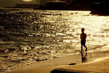 夕焼けの砂浜を走る